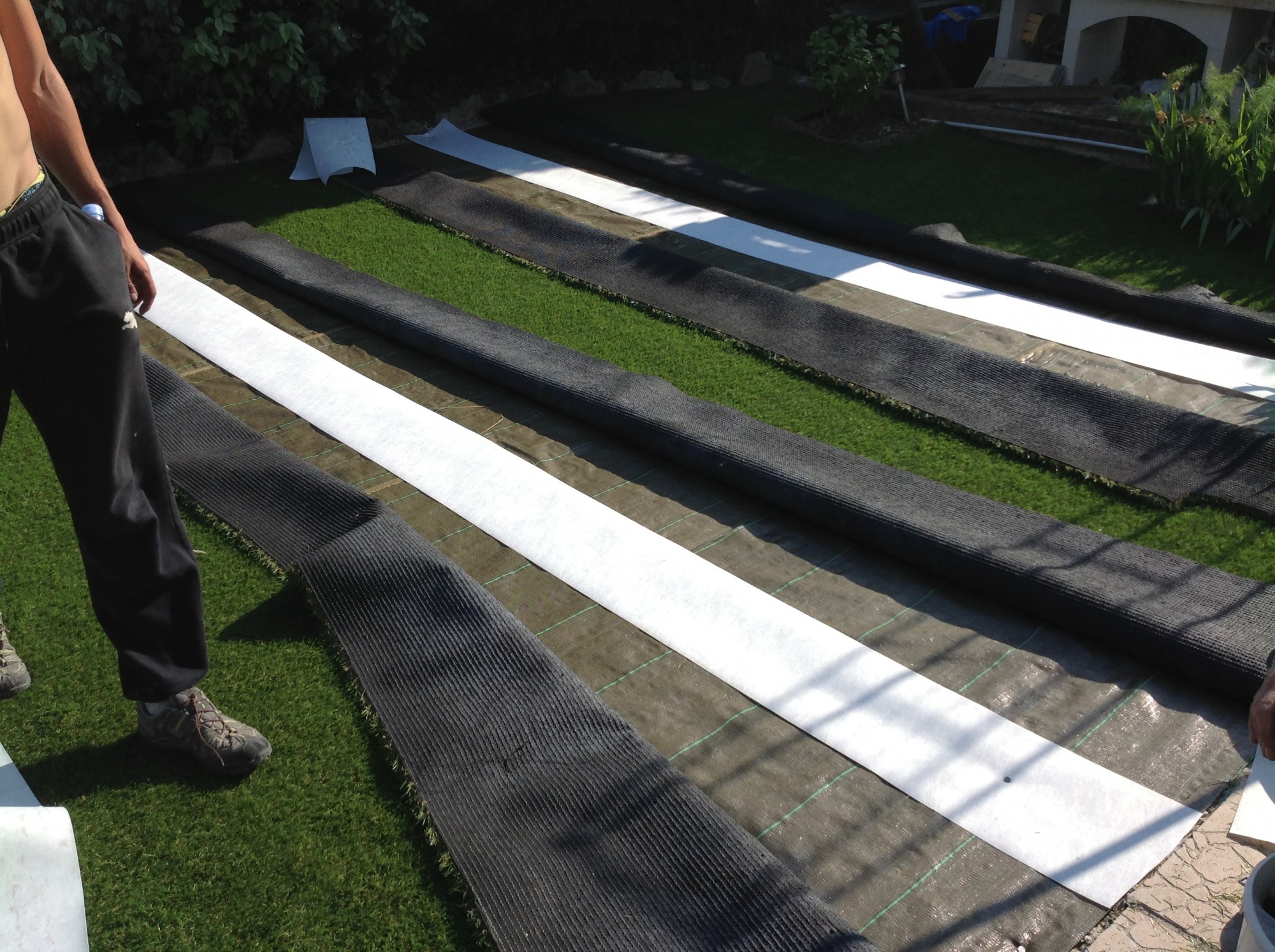 Mise en place des bandes de pontage lors d'une installation de gazon synthétique à Toulon